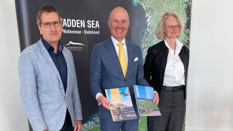 Katja Philippart and Harald Marencic hand over reports to Arno Brok. Waddenacademie.